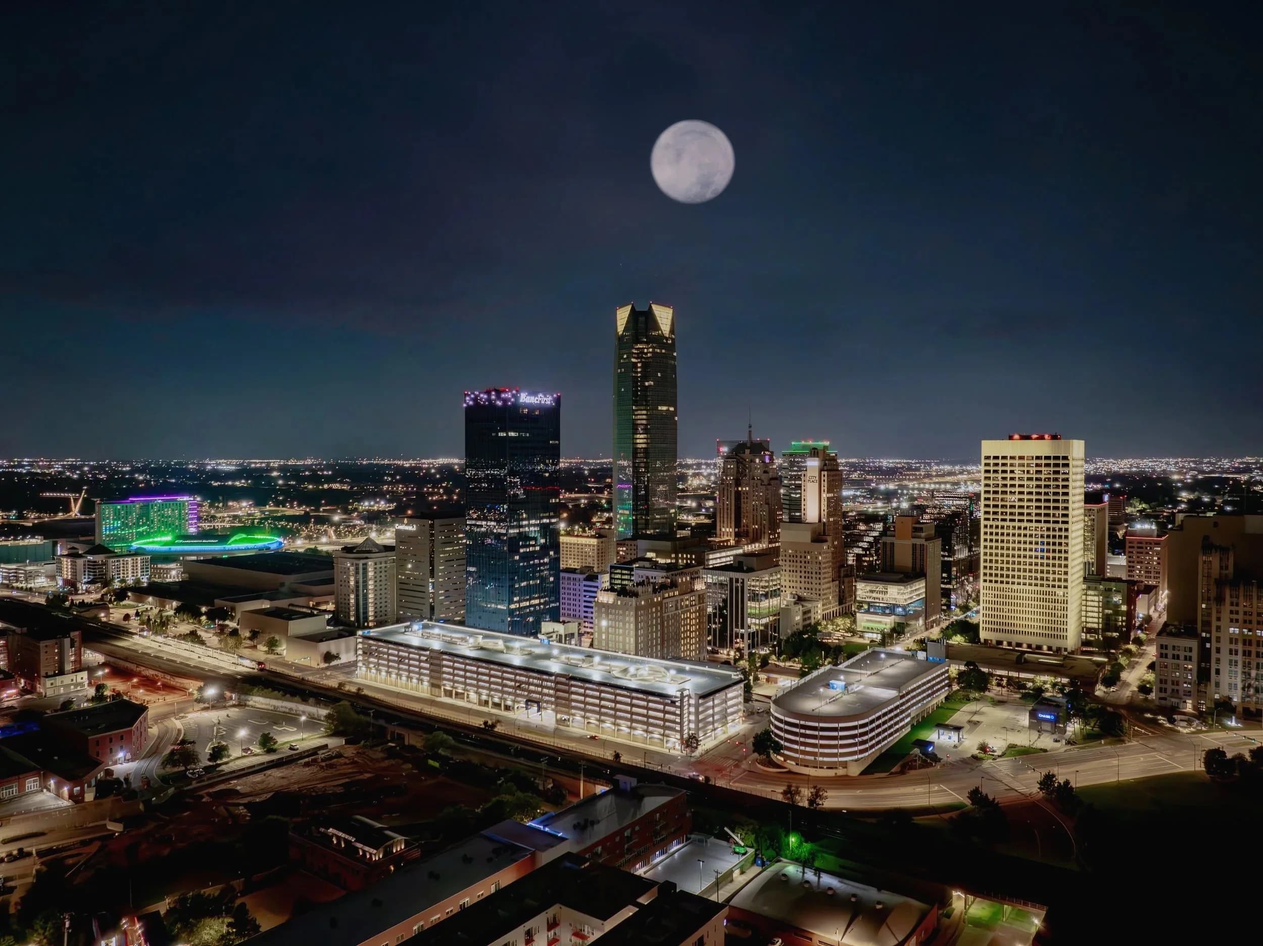 Downtown Oklahoma City at night, full moon rising over the skyline.